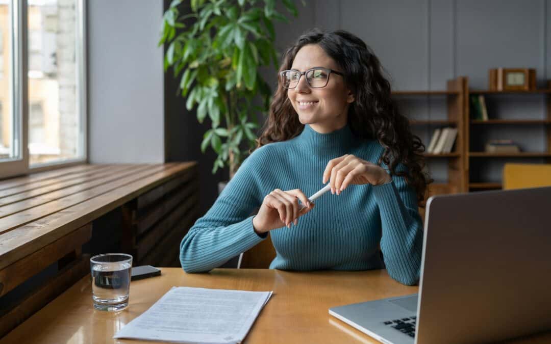 trivsel på arbejdspladsen. Glad kvindelig kontormedarbejder hviler på arbejdspladsen og holder pause for at forhindre stress